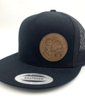 A black cap with a mesh back, with a brown logo of a squirrel pulling a wagon on the right half.