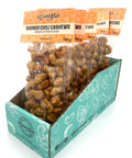 5 clear bags of candied cashews with orange labels on top.