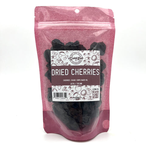 A pink bag with a clear front is filled with dark red dried cherries with a white and pink label on the front