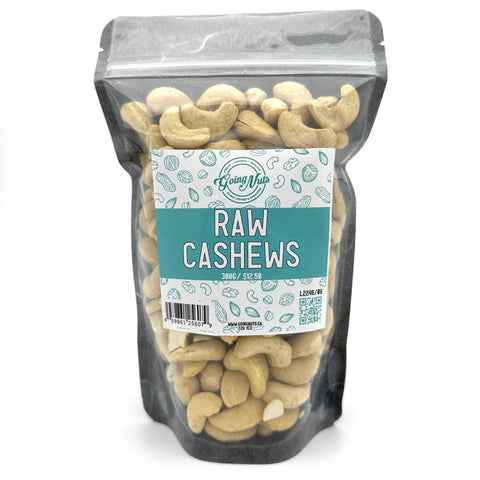 A black zippered bag filled with raw cashews with a clear front and a teal and white label on the front