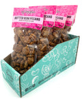 5 bags of candied pecans in clear bags with pink labels on top.