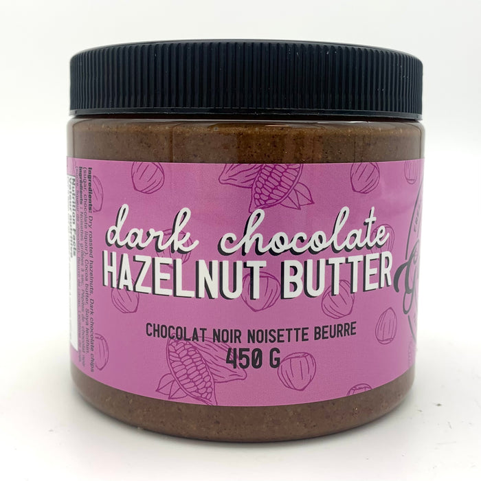 A jar of dark nut butter with a purple label which has a cocoa and hazelnut motif.