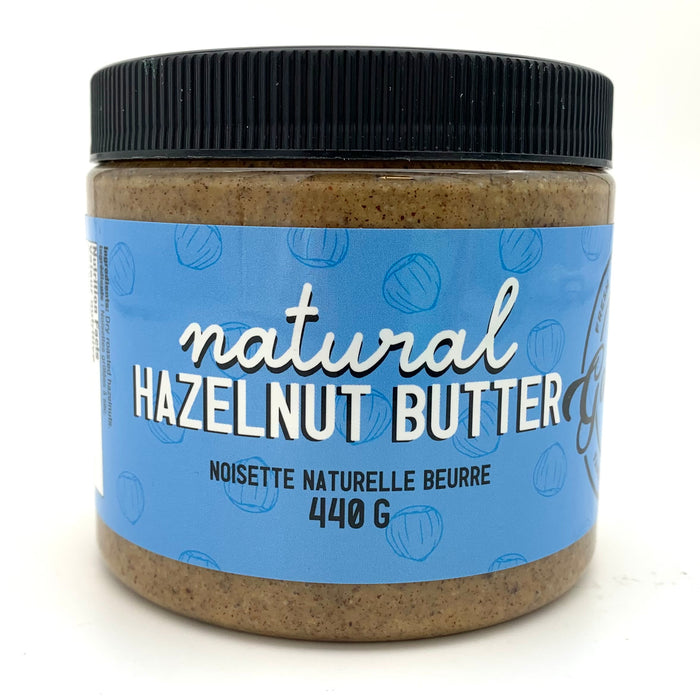 A jar of nut butter with a blue label which has a hazelnut motif.