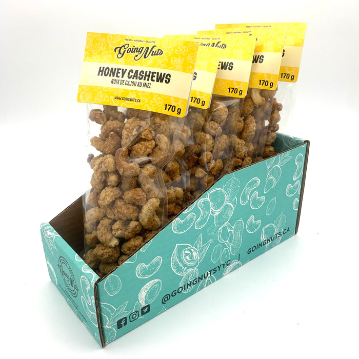 5 bags of candied cashews in clear bags with yellow labels on top.