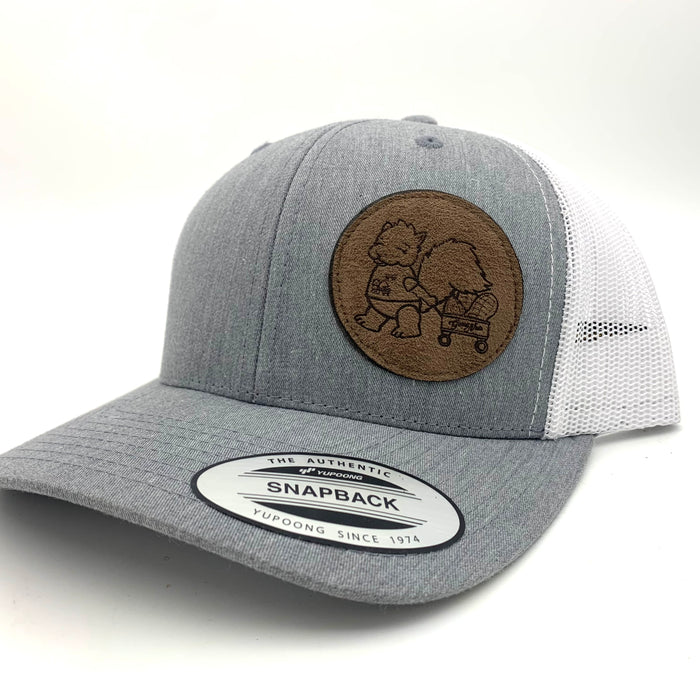 A cap with a grey front and a white mesh back, with a brown logo of a squirrel pulling a wagon on the right half.