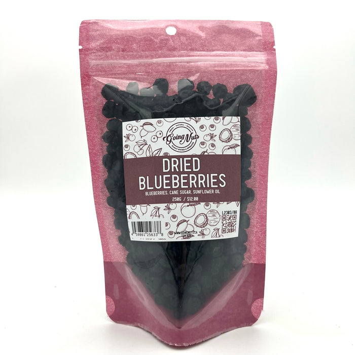 A pink bag with a clear front is filled with dried blueberries with a white and pink label on the front.