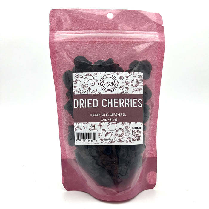 A pink bag with a clear front is filled with dark red dried cherries with a white and pink label on the front 
