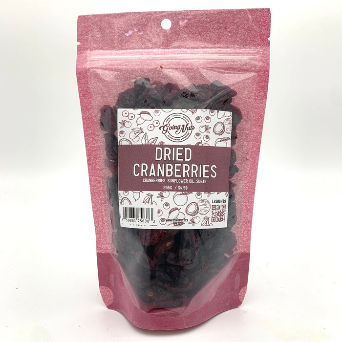 A pink bag with a clear front is filled with dark red dried cranberries with a white and pink label on the front 