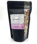 A mixture of raw nuts in a black bag with a side window. 